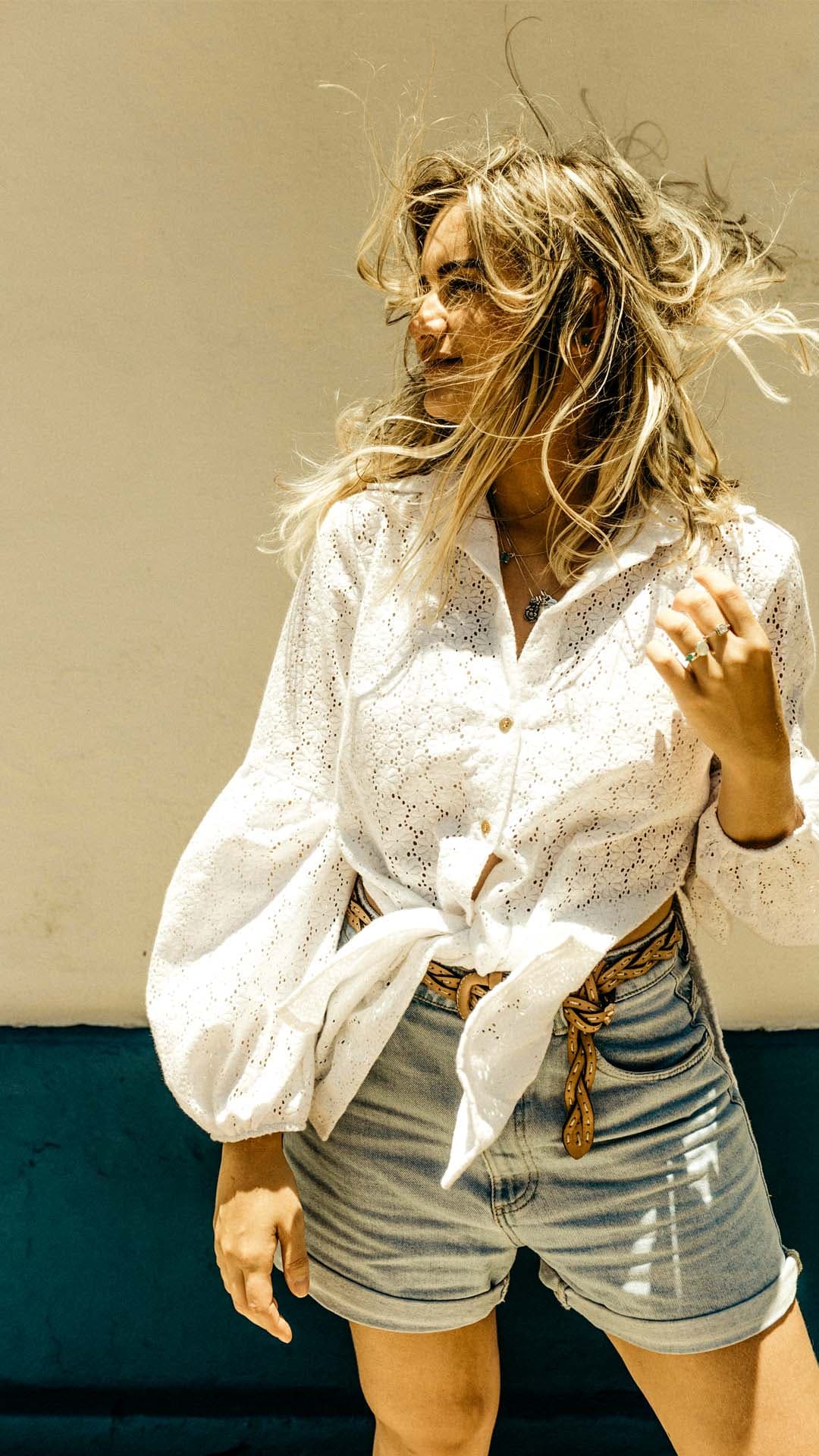 Portret van een vrouw met golvend blond haar in warm gouden licht